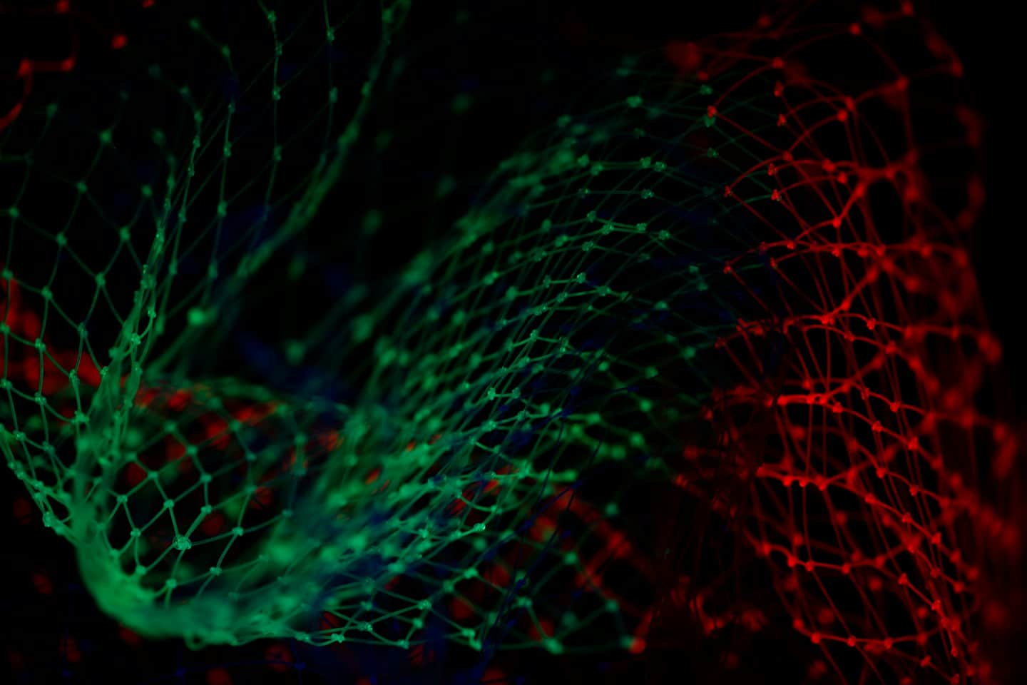 Glowing green and red digital network on a black background.